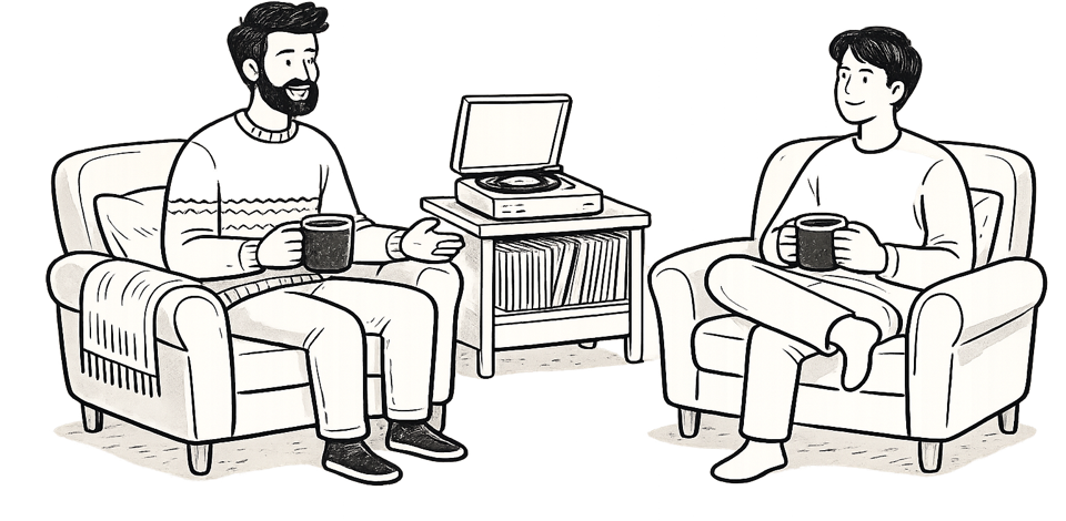 Two men sitting in armchairs, talking over a coffee